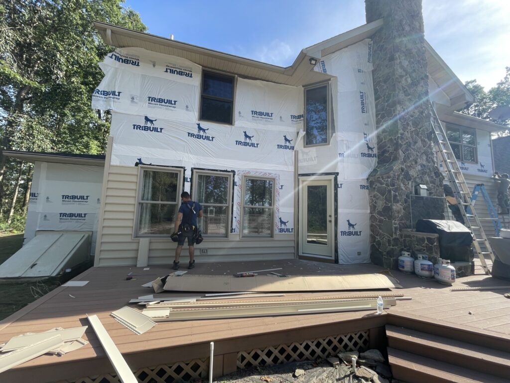 residential siding installation Grand Exteriors project worker installing new siding