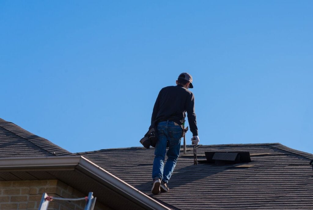 roof inspection checklist worker walking towards missing shingles